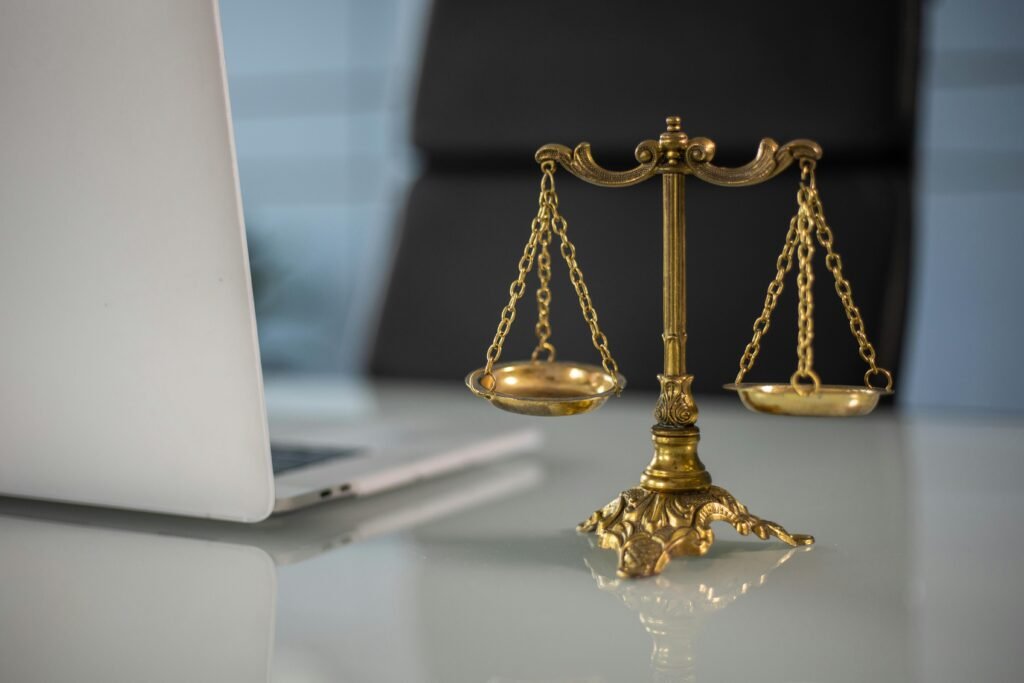 Balance de la justice placée à côté d’un ordinateur portable, symbolisant l’éthique et la responsabilité dans le numérique